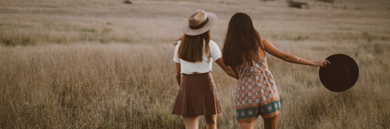 To My Best Friend, Whom I Talk to When I Struggle With Anxiety two young women walking through field together with mountain in distance