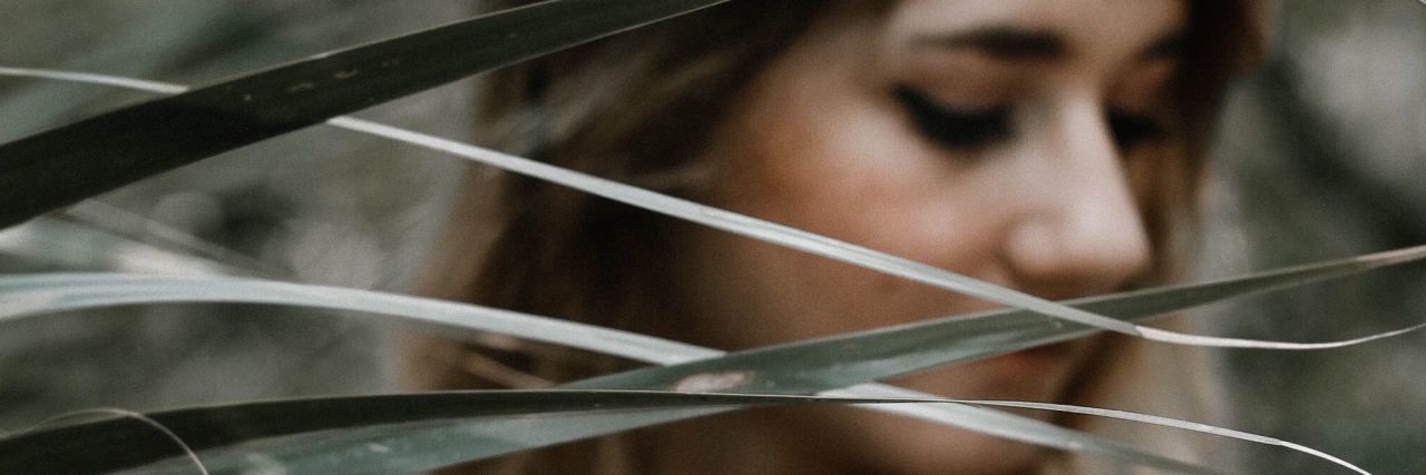 How I Healed After My Suicide Attempt woman looking through plant