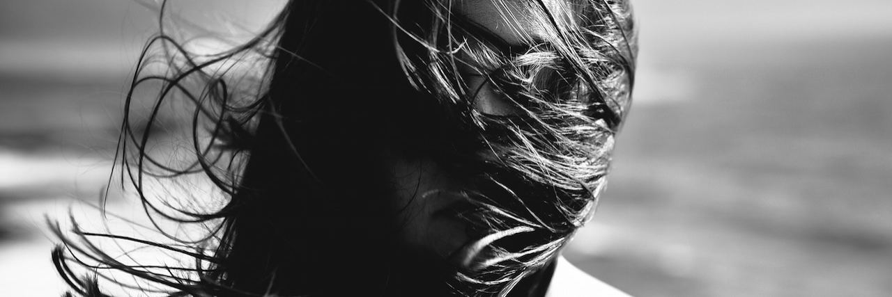 3 Ways Being Raped Still Affects My Mental Health Now woman face covered by her hair