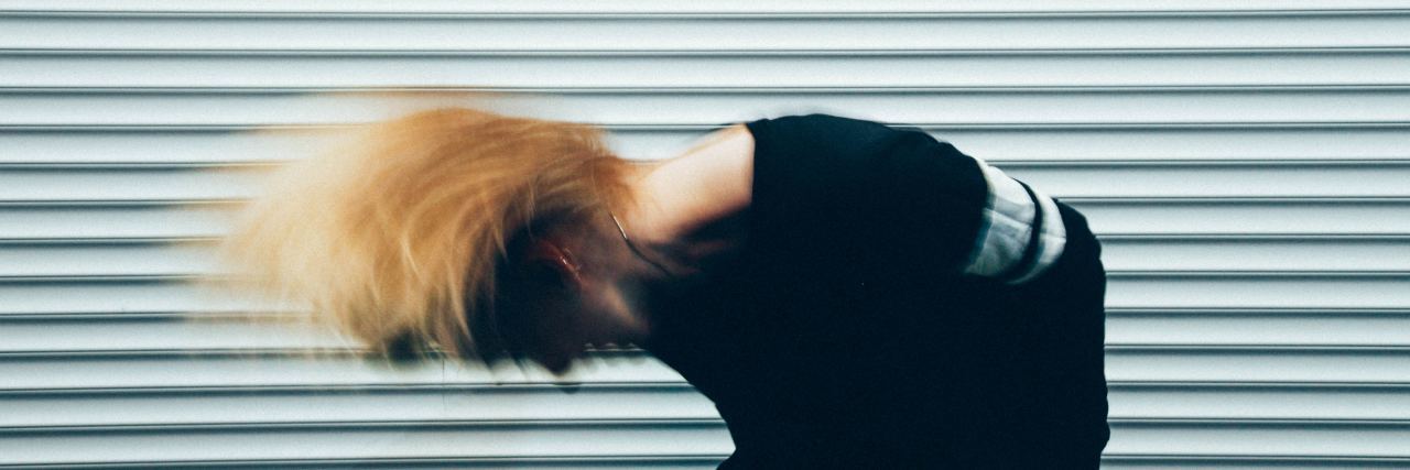 When a Doctor Referred to My Mental Illnesses as 'Crazy' woman with blonde hair shaking her hair