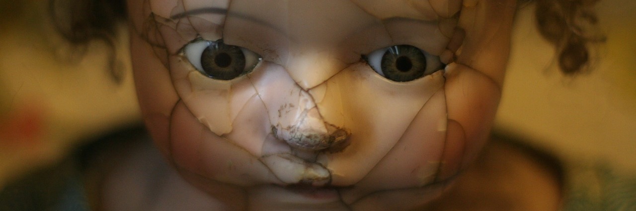 Close up of a doll's face with a shattered face