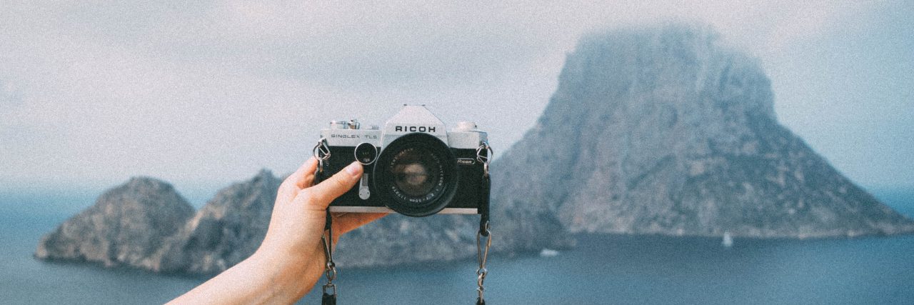 Two Years Without Insecurities person holding camera out for selfie on island