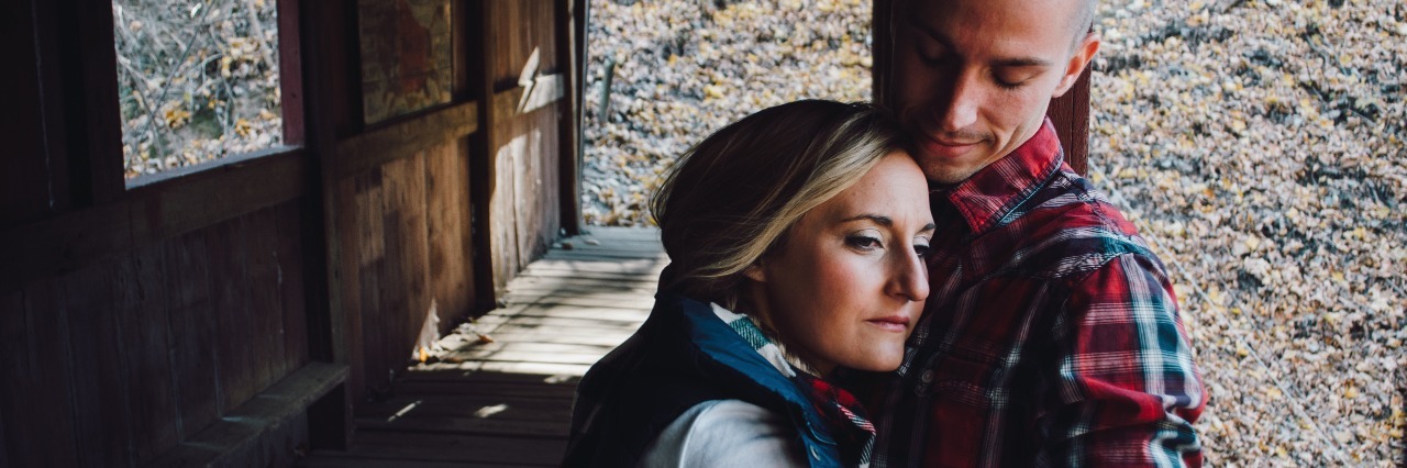 How to Help Your Loved One With a Mental Illness woman and man embracing and comforting at viewing point in nature