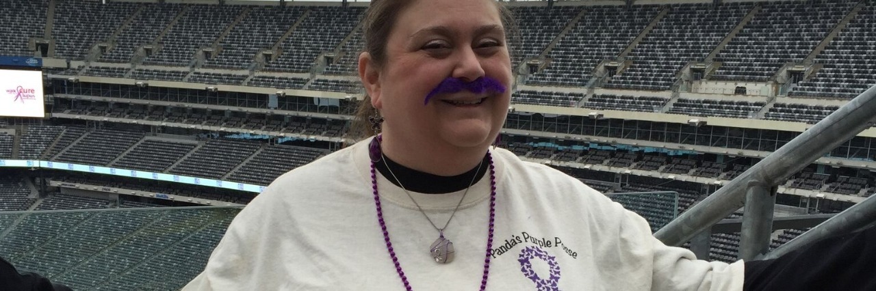 Preparing for the NJ Lupus Walk to Raise Awareness woman wearing a lupus awareness tshirt and standing in a football stadium