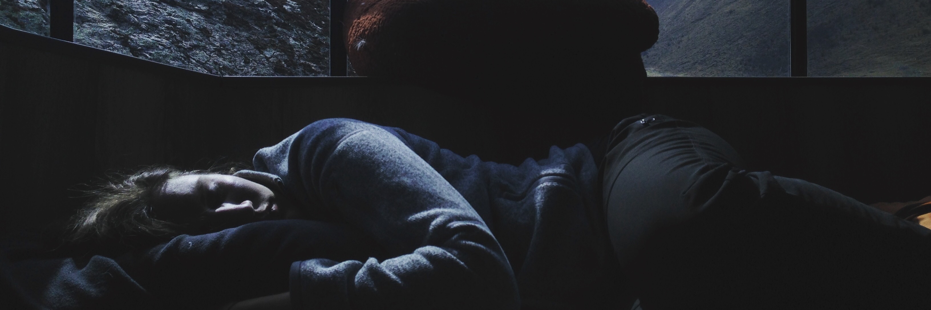 My Experience With Complex PTSD: A Poem woman lying in area overlooking mountains with window divides like bars