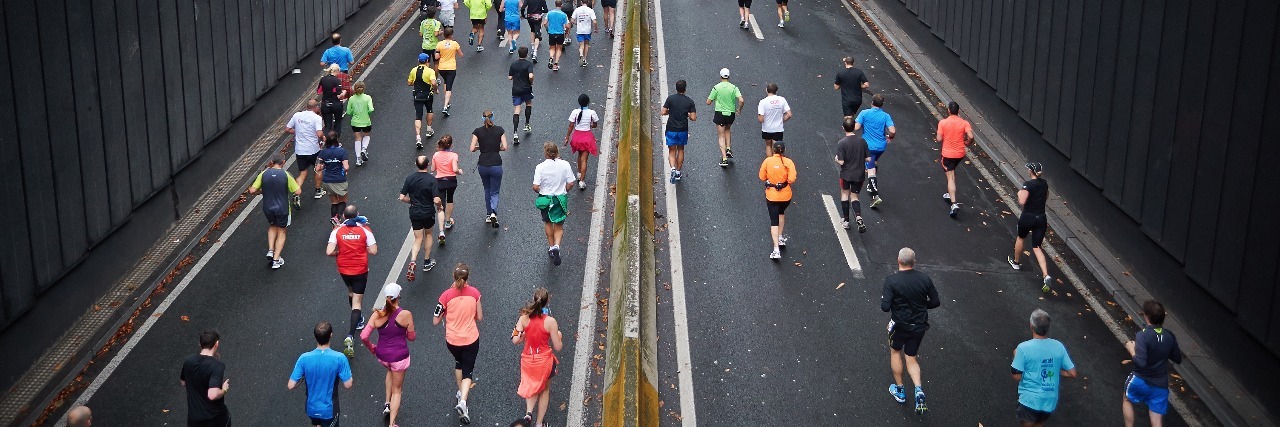 Running a Half-Marathon Is Like My Life With Mental Illness group of marathon runners running along a road