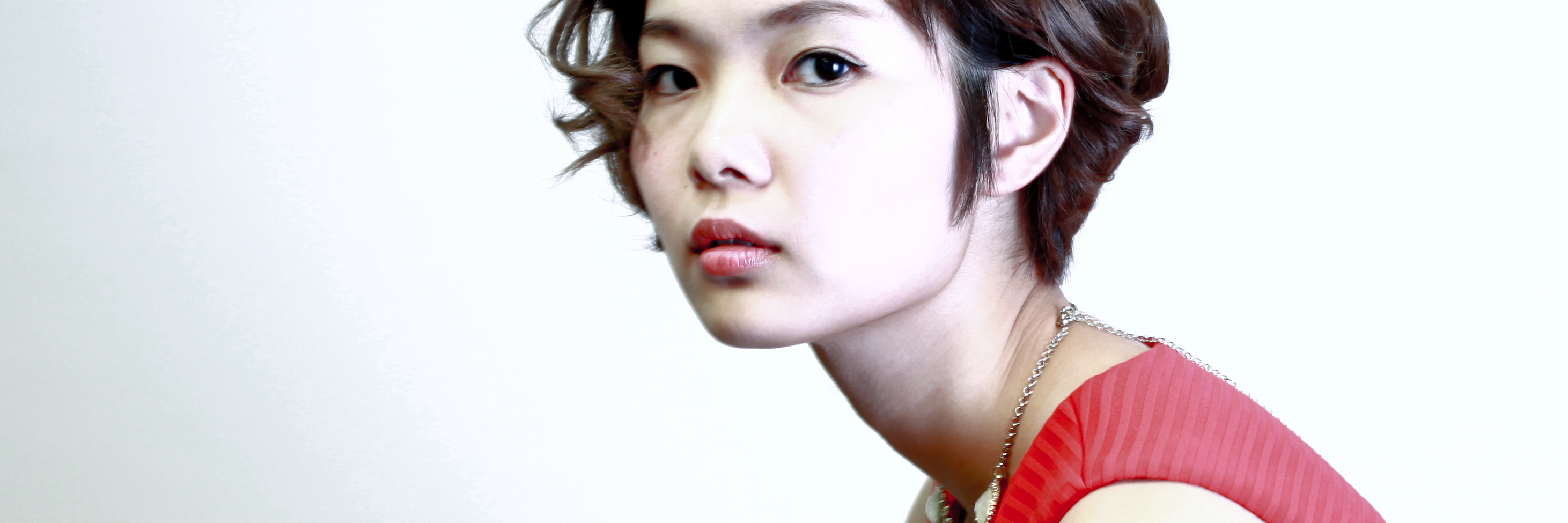 How to Help Someone With Anxiety and Depression young asian woman in red dress against white background looking depressed