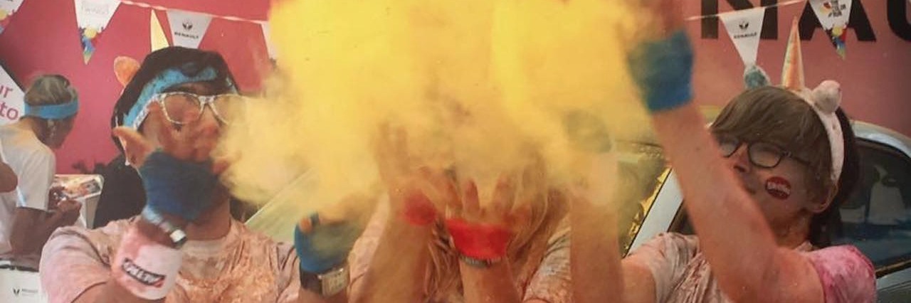 Running 5k for Thyroid UK, Meeting a Stranger With Thyroid Disease three women throwing yellow powder after completing a 5k color run
