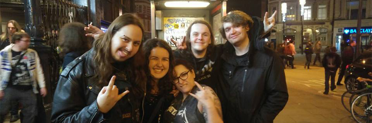How Rock and Metal Music Helped Me as Someone With Autism Five friends posing at a rock concert