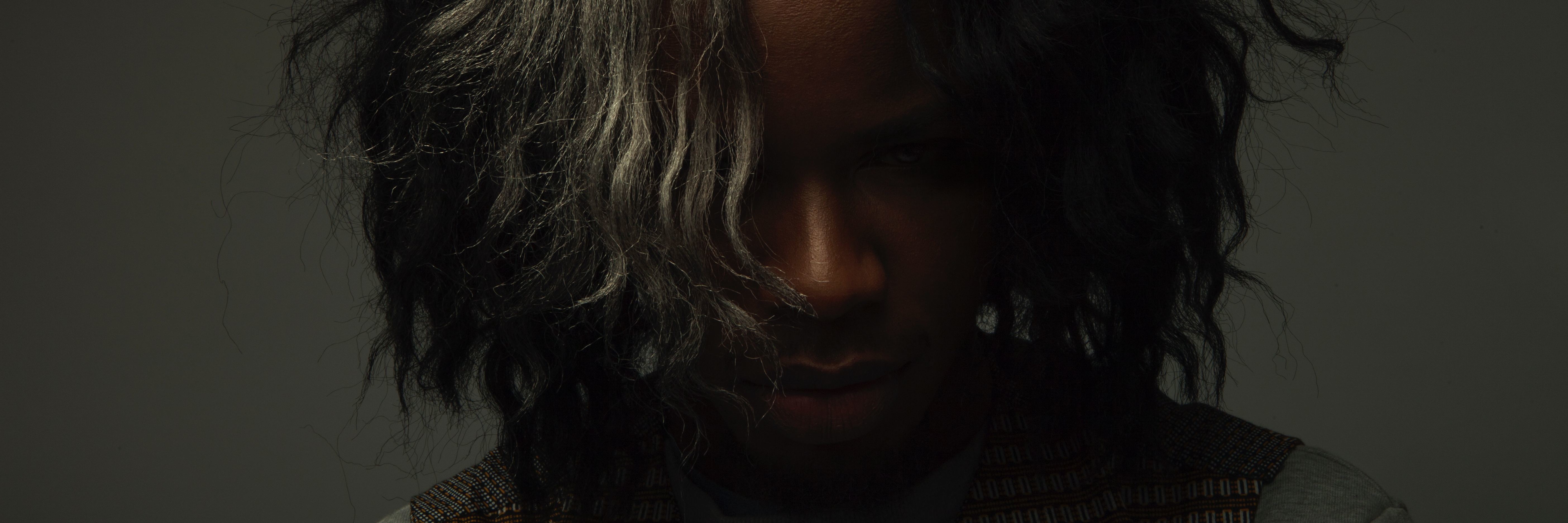 How Depression Affected My College Graduation woman of color against dark background looking down from camera