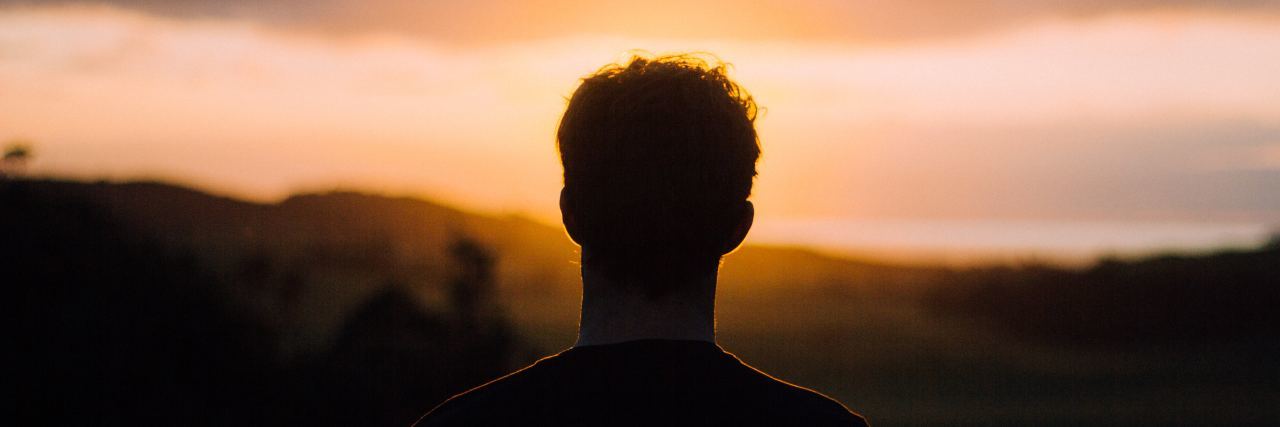 man silhouetted by sunset