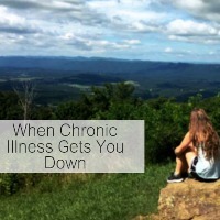 young woman sitting on a rock overlooking a valley with text saying 'when chronic illness gets you down'