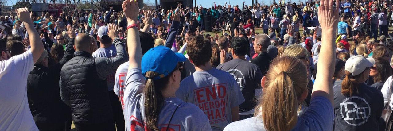 My Experience at a Walk for Addiction Awareness people raising their fists at a charity walk