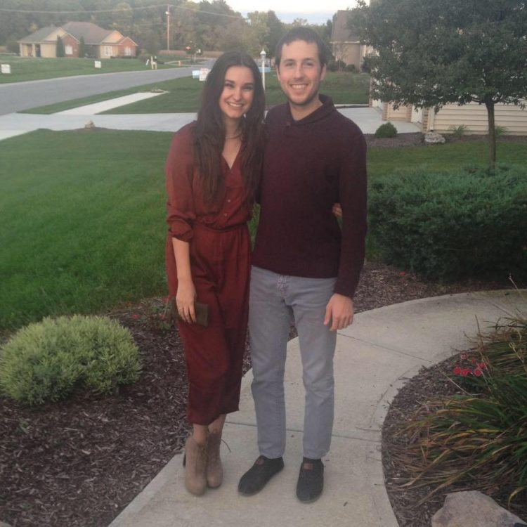 girlfriend and boyfriend standing on a sidewalk outside a home