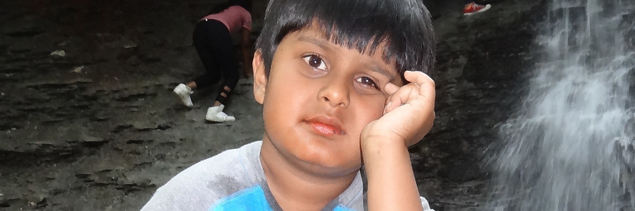 Autism Acceptance and Autism Awareness: What It Means to Me as a Mom The author's son, sitting on a rock next to a waterfall