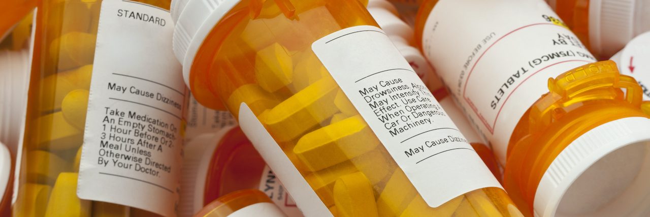 22 Secrets of People Who Take Prednisone Bottles of prescription medicine in a pile.