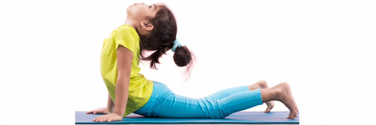 16 Signs You Grew Up With Ehlers-Danlos Syndrome A little girl does a yoga pose on a mat.