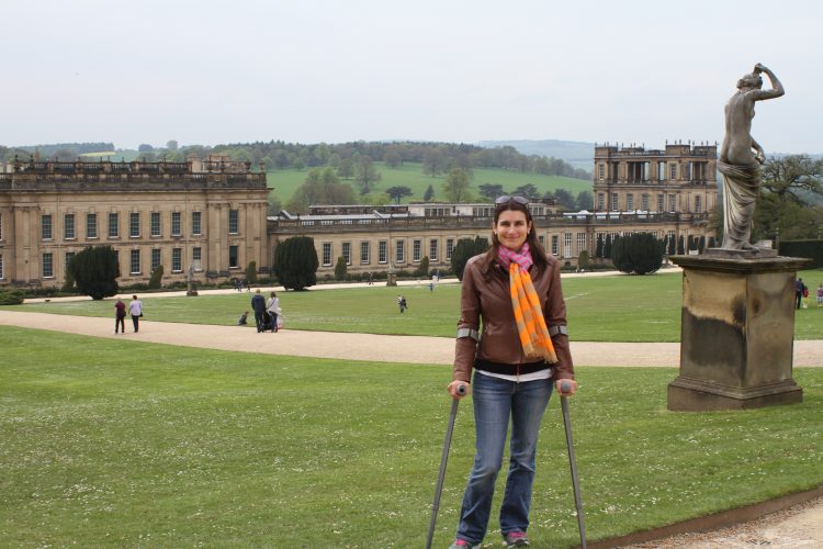 woman using walking devices and standing in front of large building