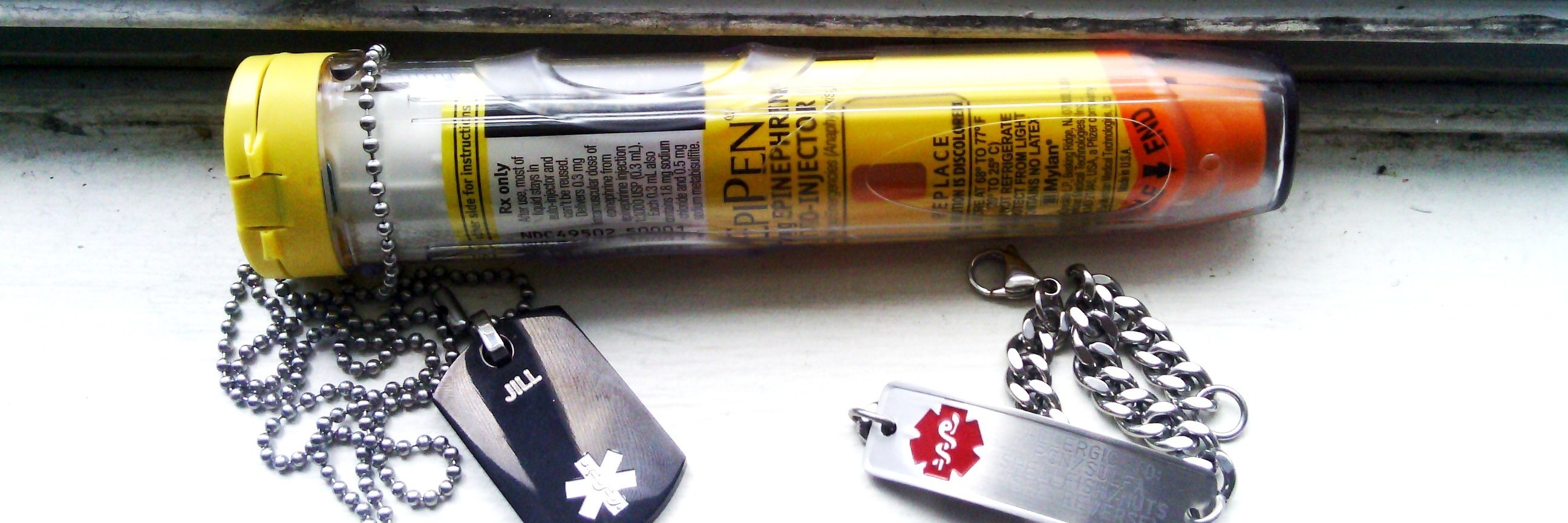 a woman's epi-pen and medical bracelets