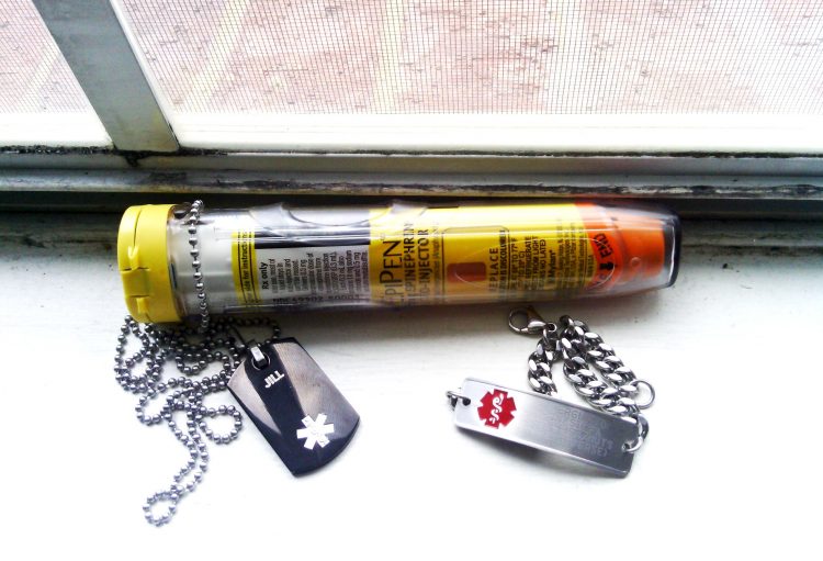 a woman's epi-pen and medical bracelets