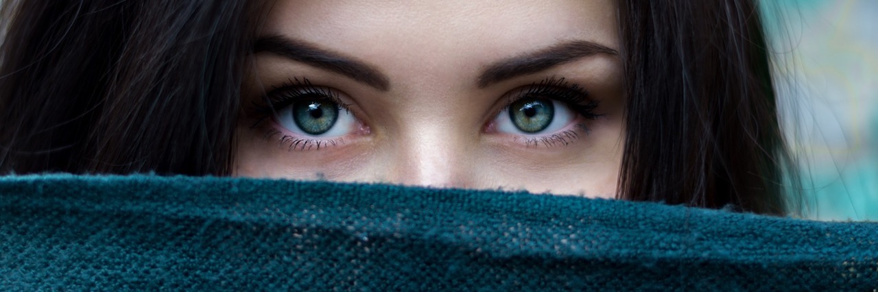 woman with a blue scarf covering the lower half of her face