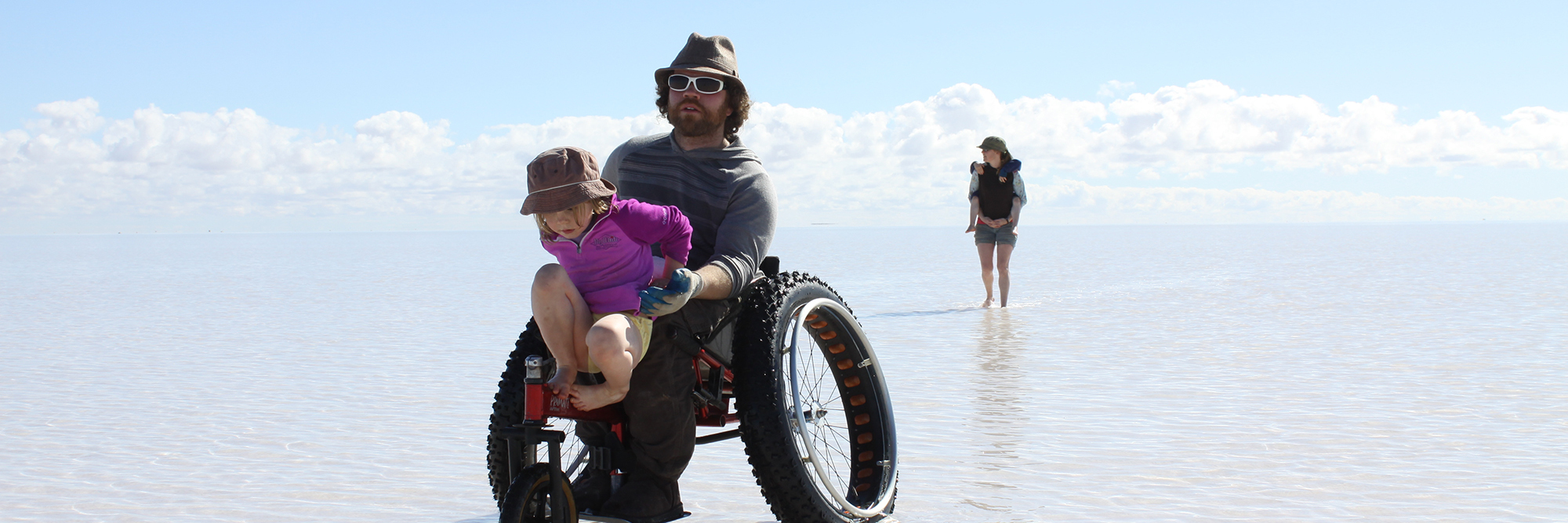 The Challenges of Parenting With a Disability Emma and her husband on the beach with their kids.