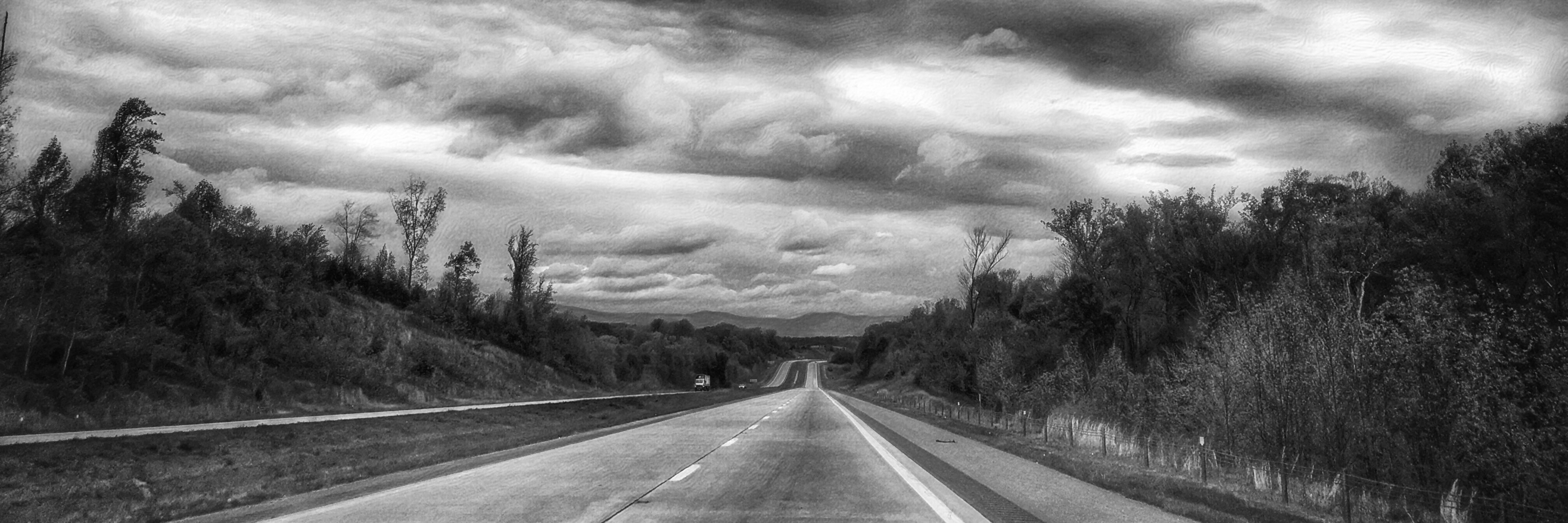 Why I Lie When You Ask Me How I'm Feeling A black and white picture of an empty road on a cloudy day.