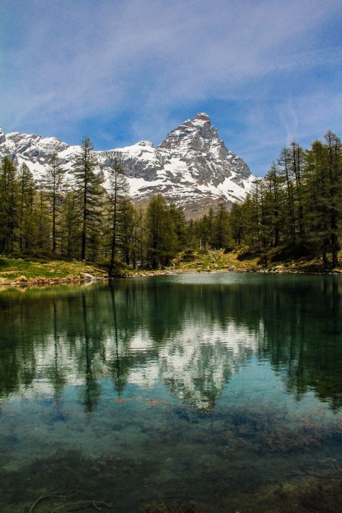 A beautiful photo of snow-capped mountain scenery, reflecting on the water.