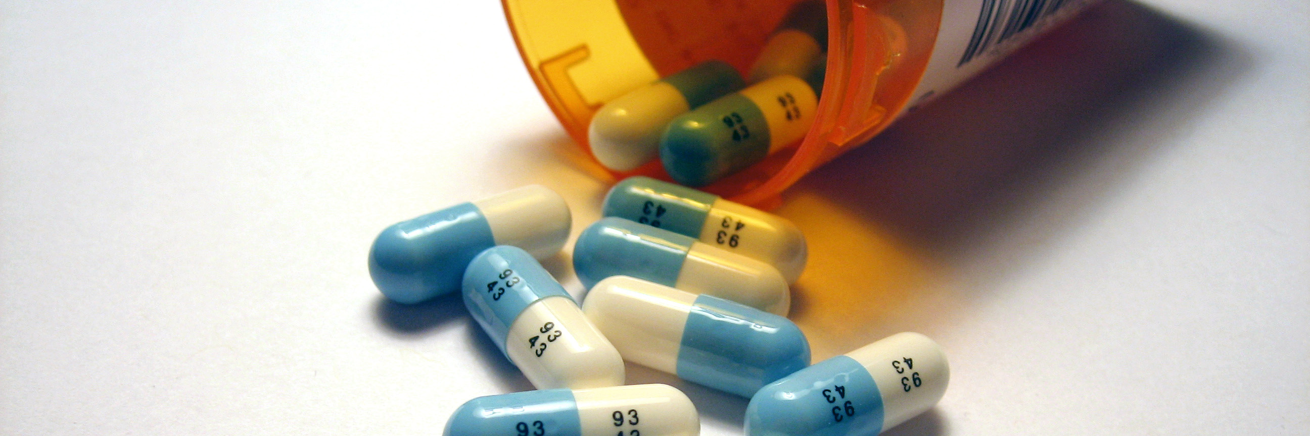 Why There's Nothing Wrong With Taking Medication for Mental Illness medication spilled from medicine bottle on white table