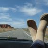 woman's feet propped up on the dashboard of a car on a road trip
