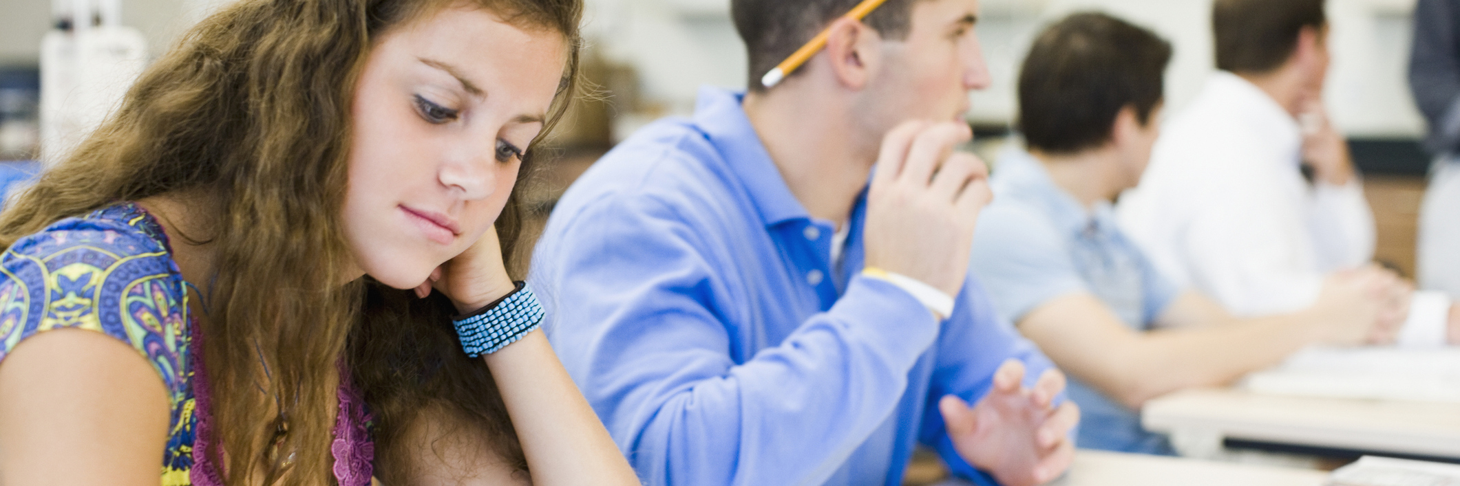 female student writing at her desk in the classroom