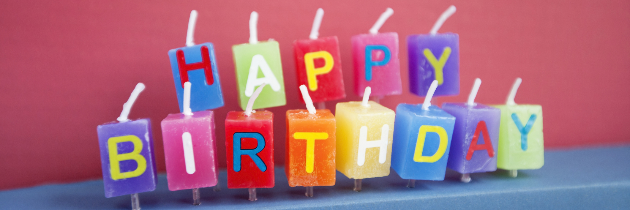 Unlit birthday candles over colored background
