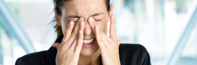 woman rubbing her eyes