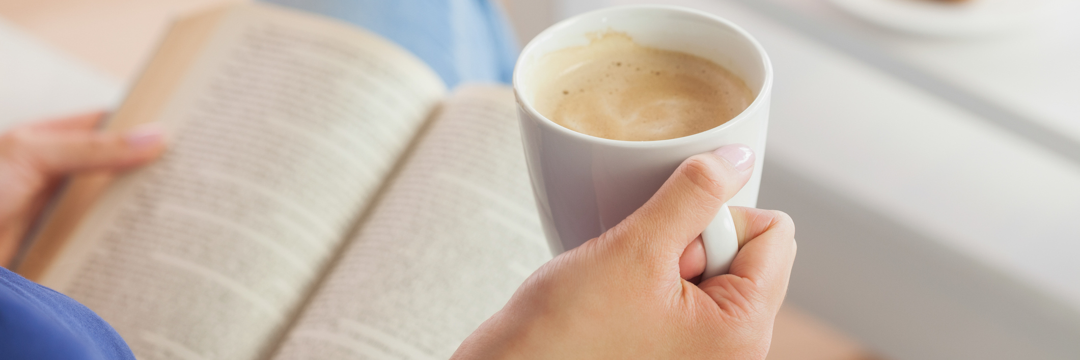 Mark Manson's Book Helped Me Cope With Depression Woman sitting on the sofa reading a book holding her coffee mug