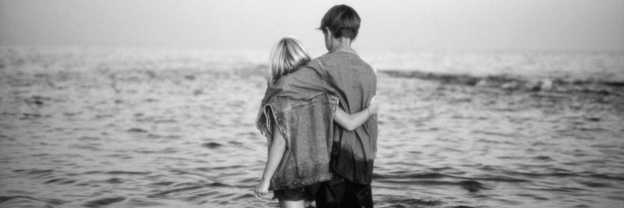 To the Friends Who Love Me During Isolating Episodes of Depression Girl (6-7) and boy (8-11) walking in sea, rear view