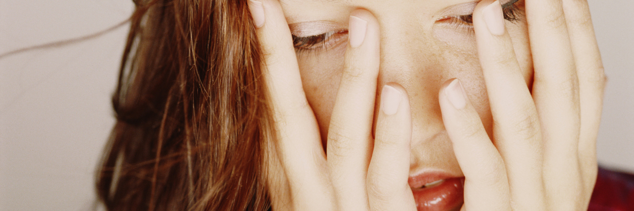 What Not to Say When I'm Having a Panic Attack Woman covering face with hands, looking down