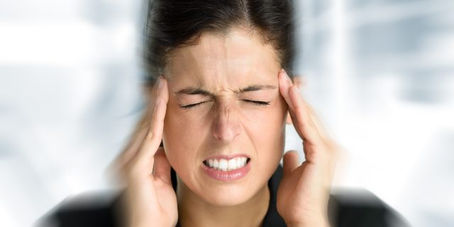 woman feeling dizzy and holding her head