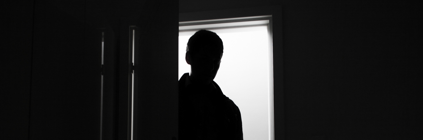 silhouette of a man standing in a doorway