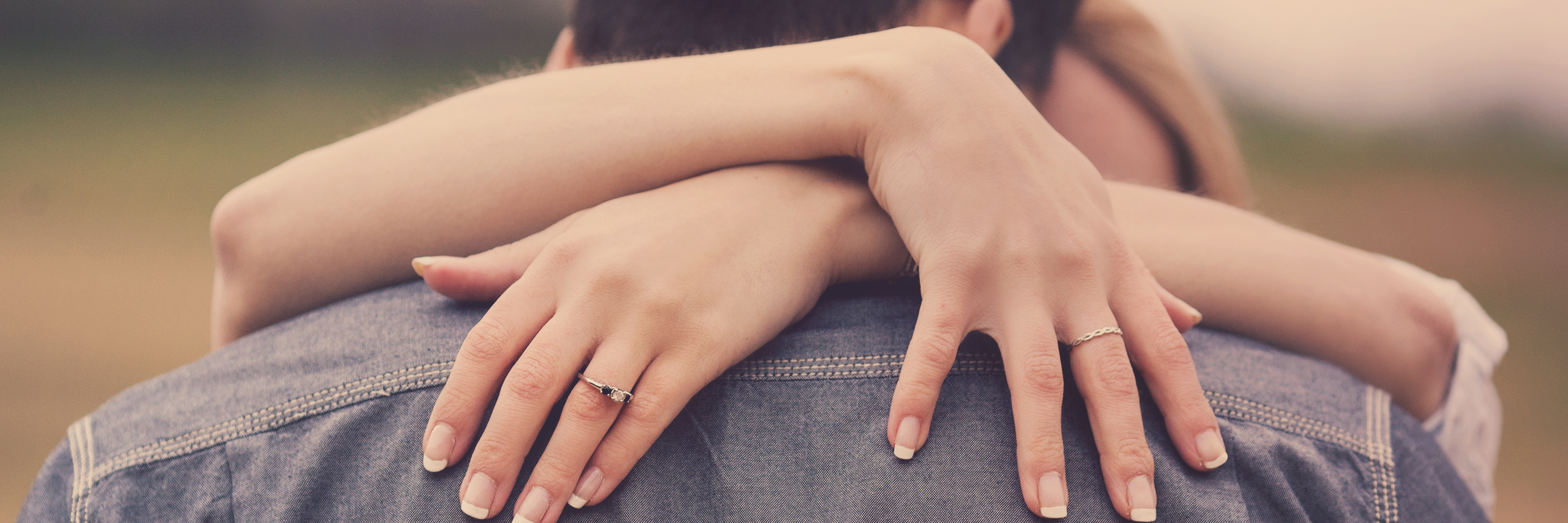 Getting Diagnosed With Fibromyalgia Before Your Wedding a couple hugging with the woman wearing an engagement ring