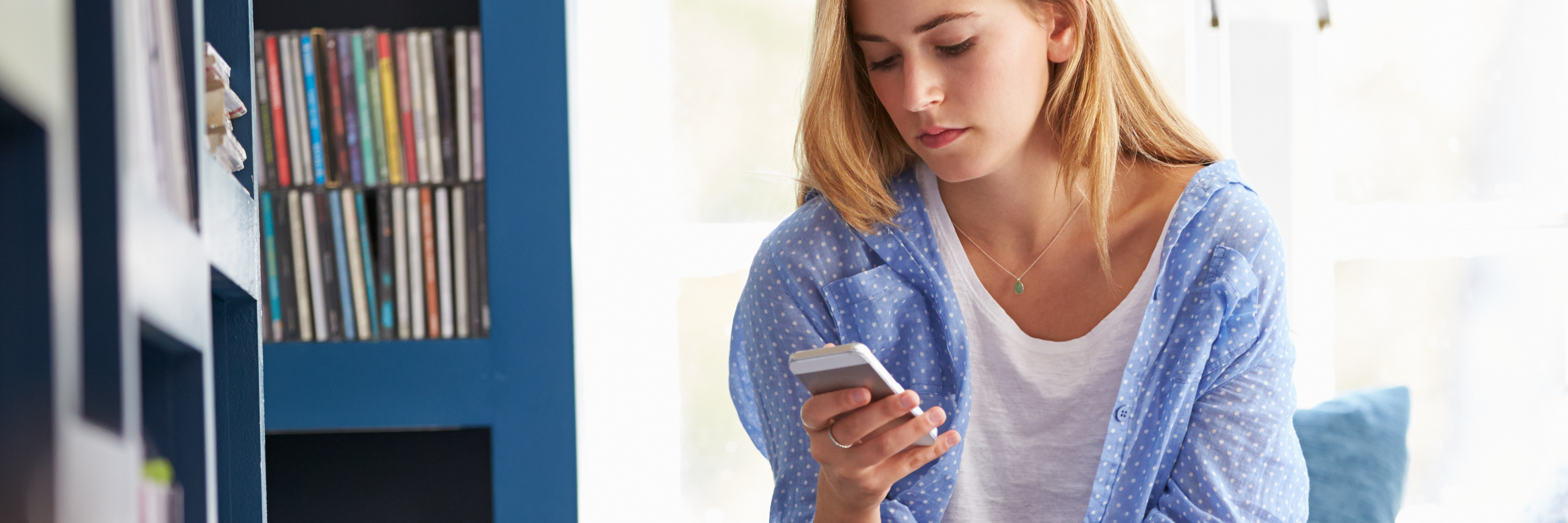 What It's Like to Be Anxious When Getting Ready for Work woman sitting on couch with mobile phone