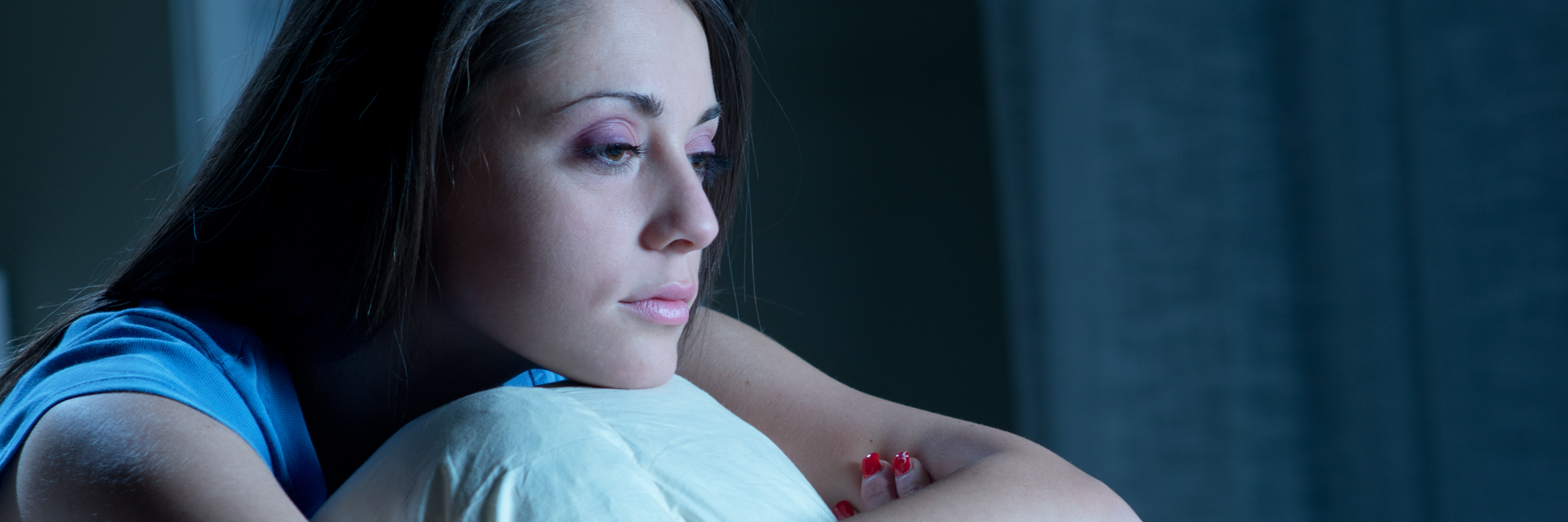 The Truth About PTSD, Anxiety and Nightmares young woman sitting up in bed with insomnia