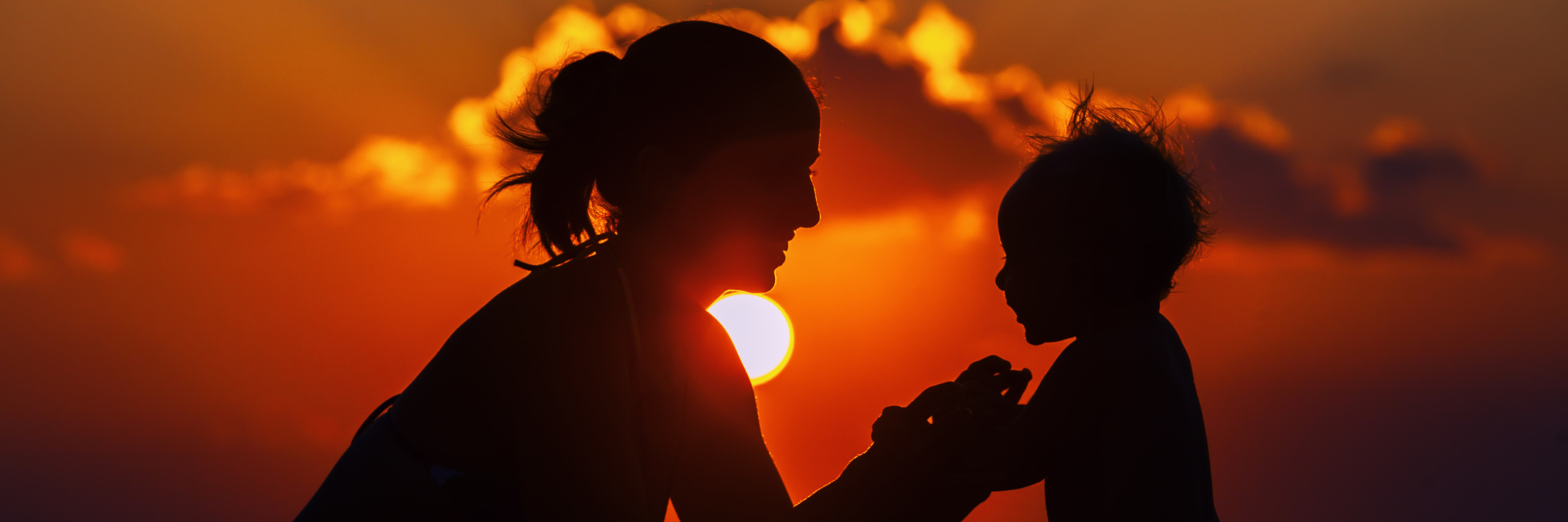 Parenting a Child With a Disability Happy mother and joyful son sunset silhouette.