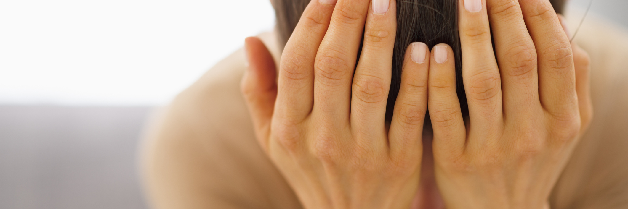 woman sitting on the couch with her head in her hands