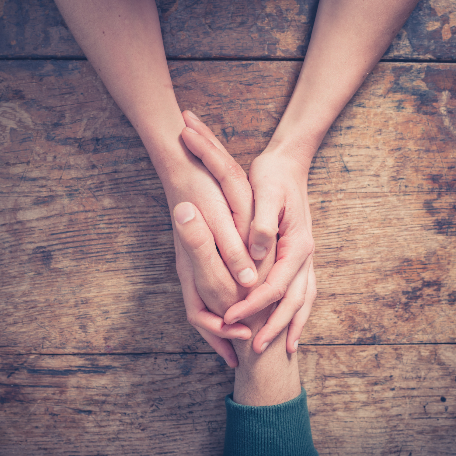 a person holding their friend's hand in support