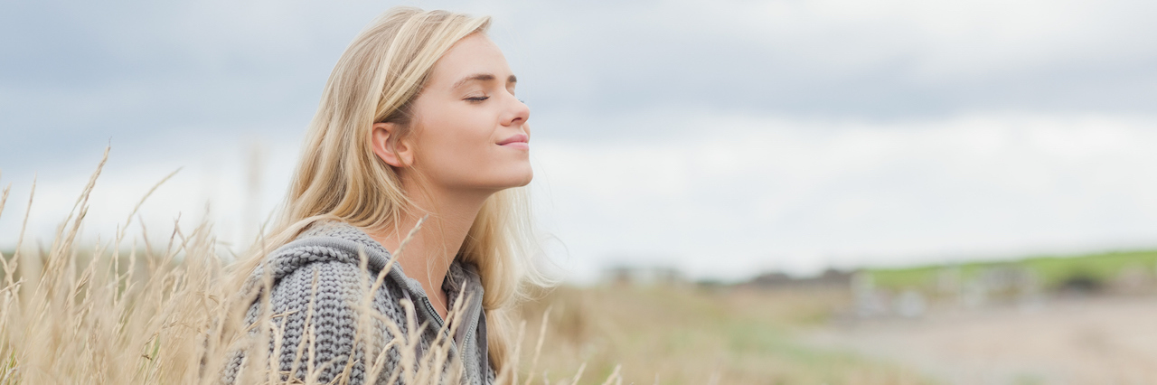 Overcoming the Perfectionism at the Root of My Anxiety a woman sitting in field of grass