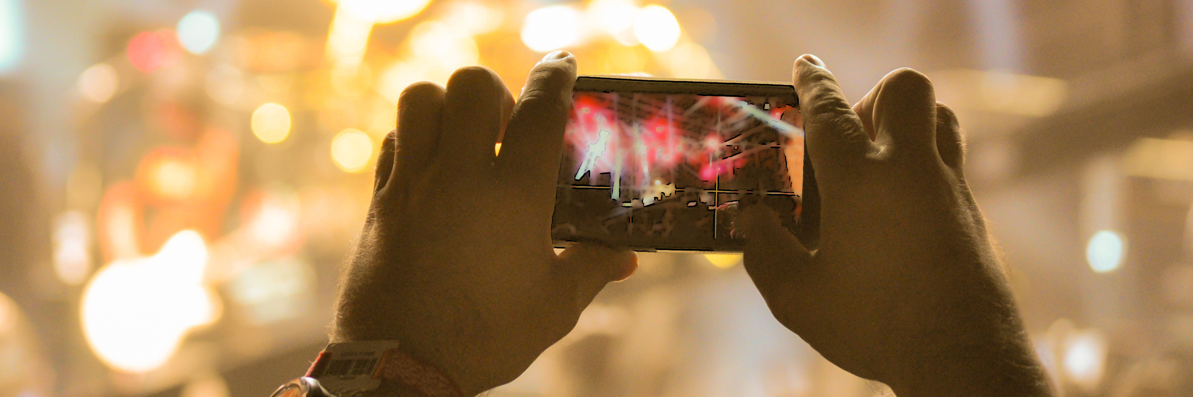 What It Was Like Attending a Concert as Someone With a Chronic Illness Someone taking a photo at a concert on their cell phone.