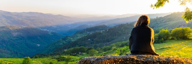 scenic view at Peneda-Geres National Park, northern Portugal of woman watching sunset over valley