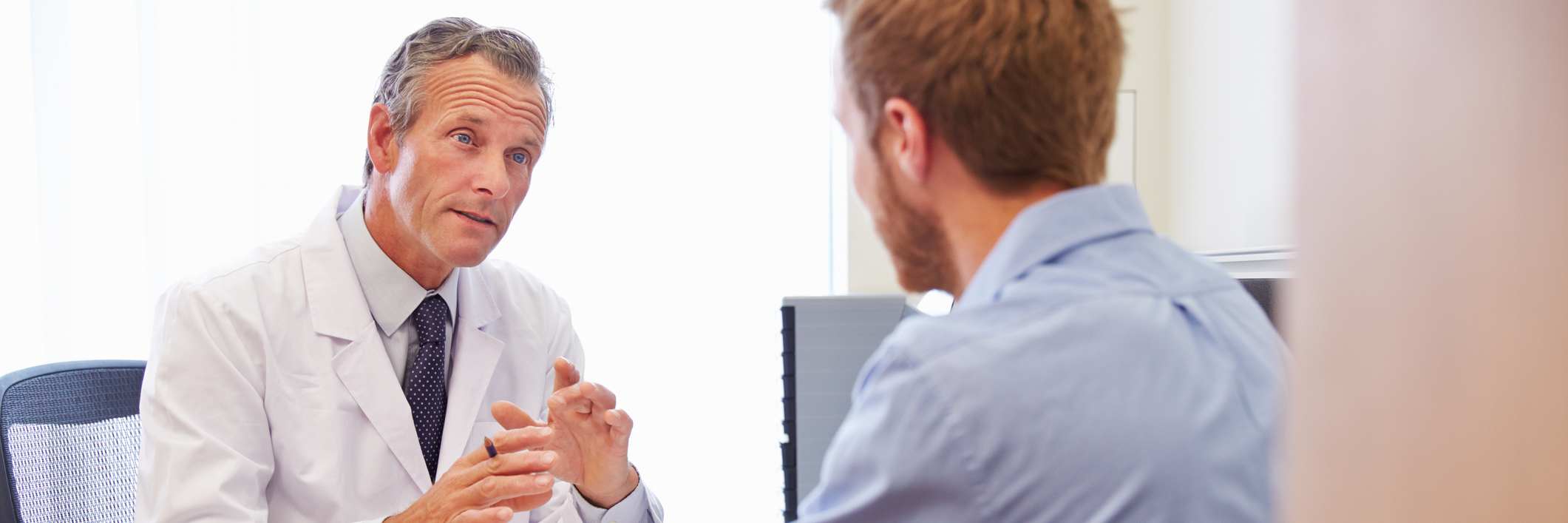 Finding a Cure for Mysterious, Undiagnosed Symptoms man talking to doctor