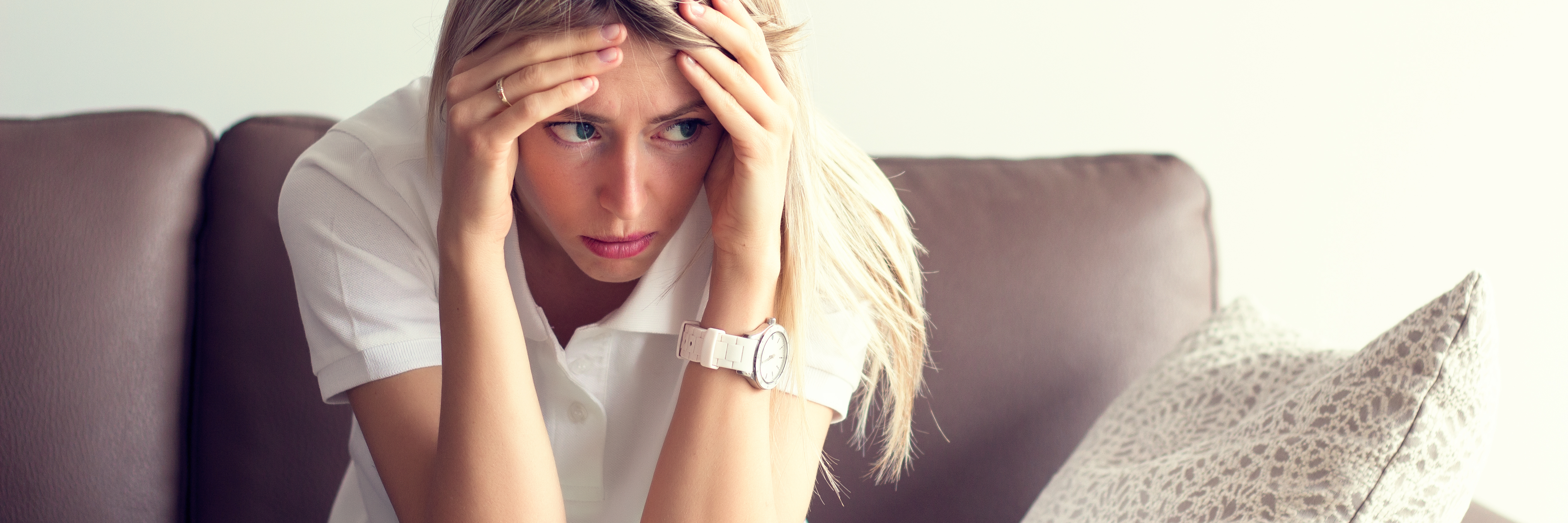 How PTSD Makes You Feel Like Abusers Are in Control young woman sitting on sofa depression