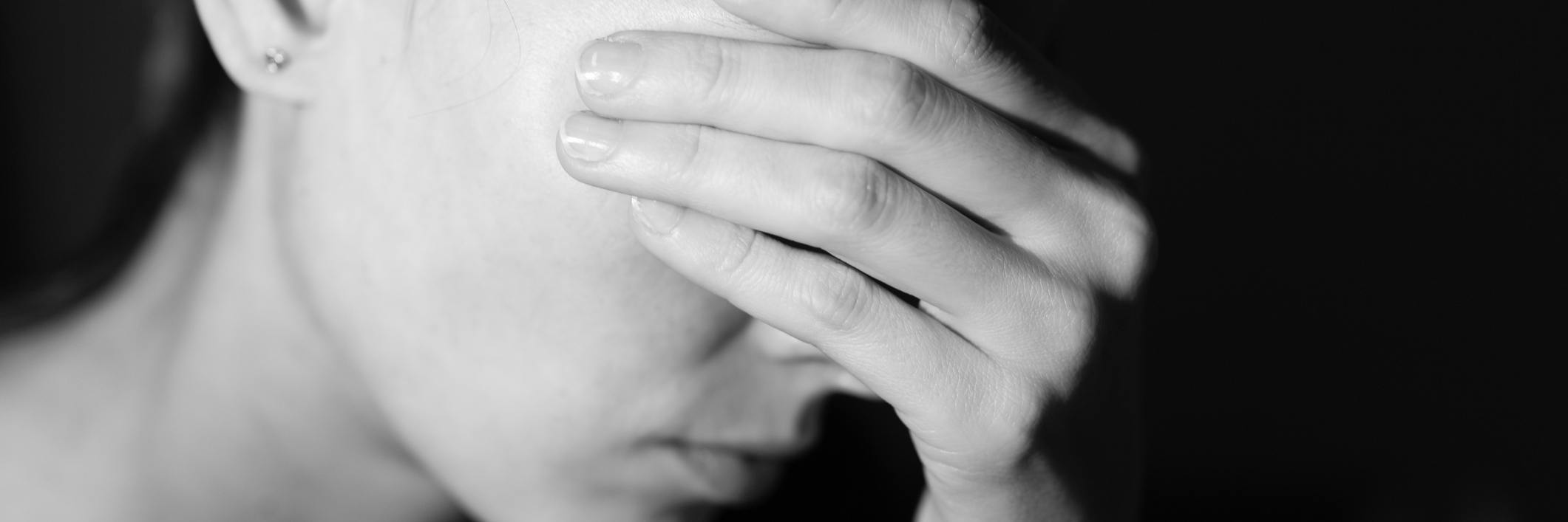 black and white photo of woman covering her face with her hand